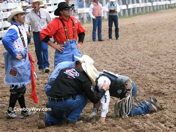 A bull rider gets help A bull rider gets help