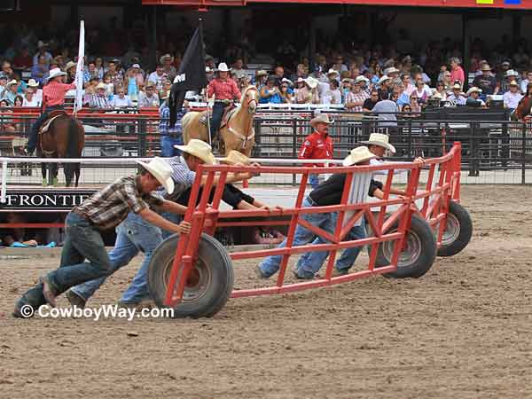 Volunteers push the long, heavy gate 
that separates the arena from the racetrack to close it