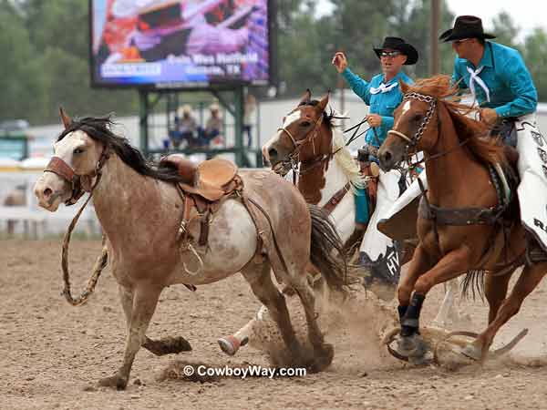 Pickup men move in on a saddle bronc Pickup men move in on a saddle bronc