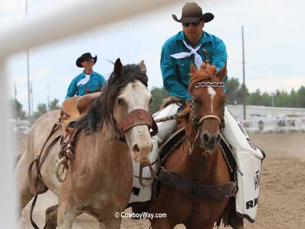 A saddle bronc comes down the fence