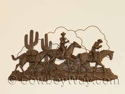 Cowboys and pack horses metal art on a wall