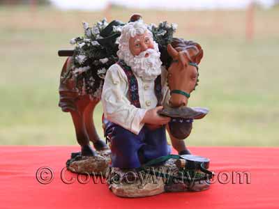 A cowboy Santa figurine with horse and Christmas tree