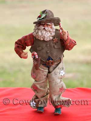 A cowboy Santa figurine with mistletoe and candy canes
