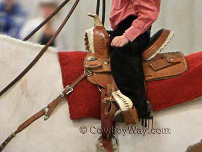 A toddler in cowboy boots at a horse show