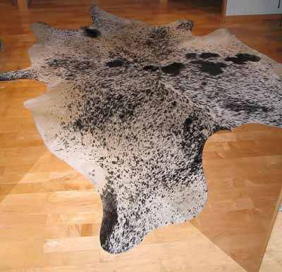 A wooden floor with a cowhide rug