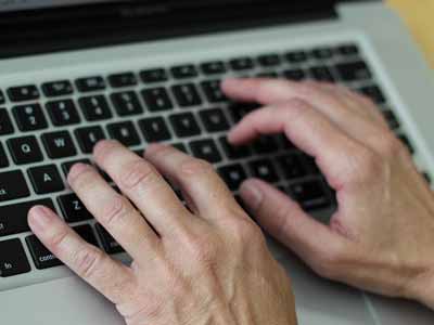 Hands typing a horse for sale ad on a keyboard