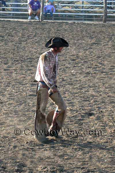 A bronc rider walks back