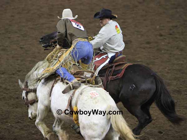 A saddle bronc rider gets off on a pickup man