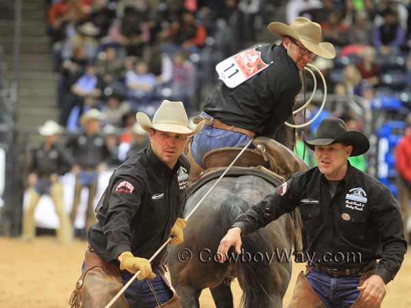 A roper takes a calf to be branded