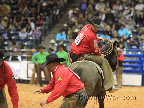 A roper looks back at his calf and teammates