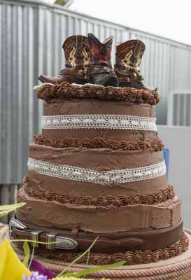 A chocolate wedding cake with cowboy boots for a cake topper