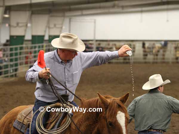 In wild cow milking a judge checks for milk in the bottle