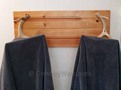 Two towels hanging on an antler towel rack