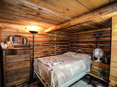 A rustic/Western room with a plain bedspread