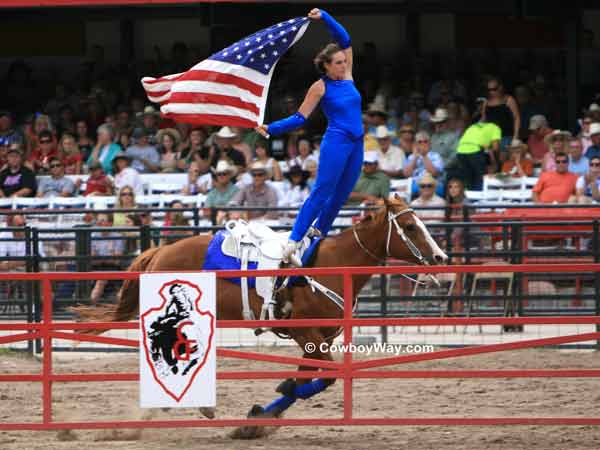 A trick rider carries an American Flag