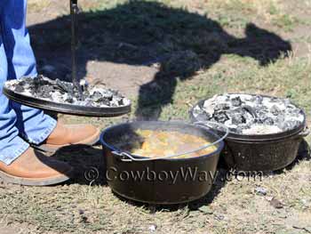 Camping Dutch ovens with coals on their lids