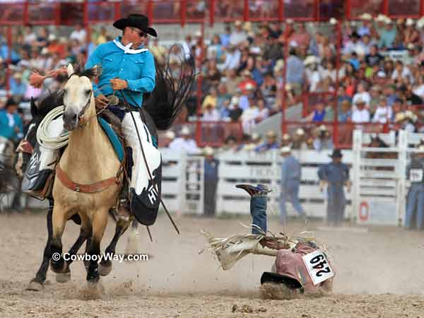 A saddle bronc rider crashes