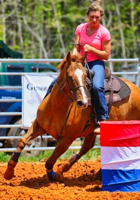 A barrel racer turning a collapsible barrel