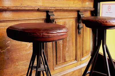Cowhide bar stools with brown leather seats and swivels