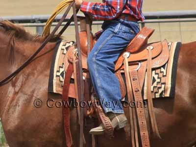 A Dakota roping saddle with a youth rider