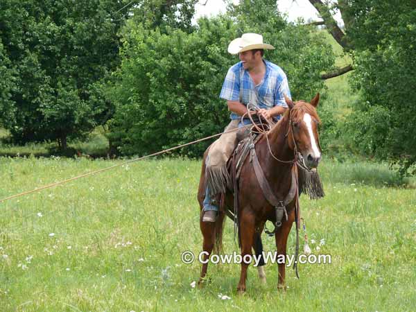 A cowboy on his horse laughs