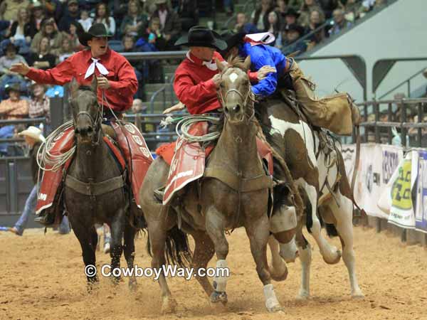 Pickup men move in to help a bronc rider