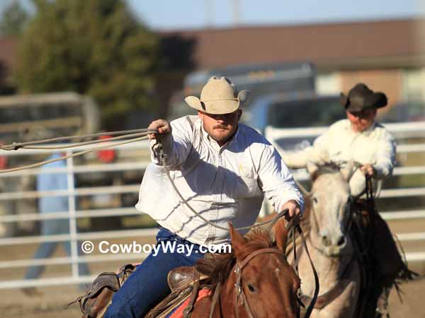 Two cowboys concentrate on roping a steer