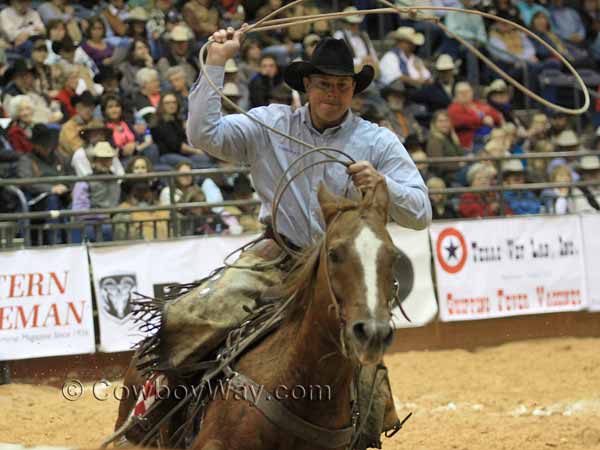 A roper concentrates as he swings his loop