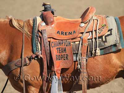 A used trophy roping saddle with lettering