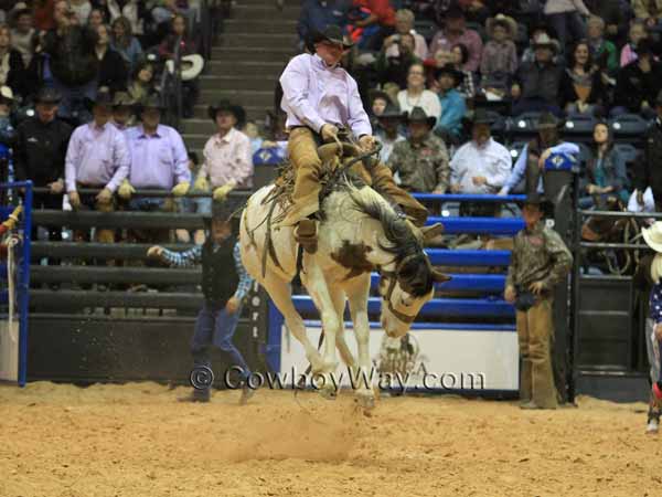 Ryan Wakefield high in the air on a spotted bronc