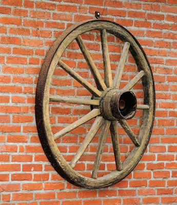Wooden wagon wheel on a brick wall