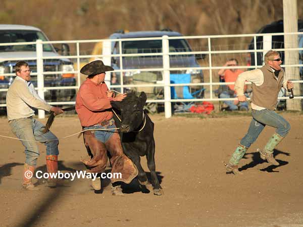 A cowboy runs with a bottle of milk to the judge